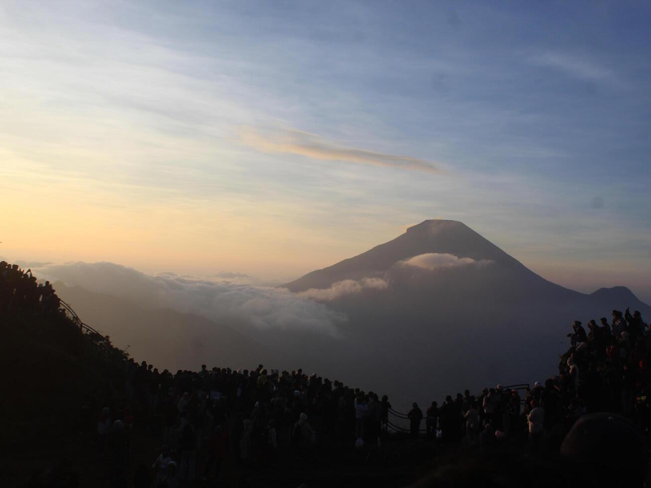 view of the sunrise on Mount Dieng with clouds covering the mountain photo