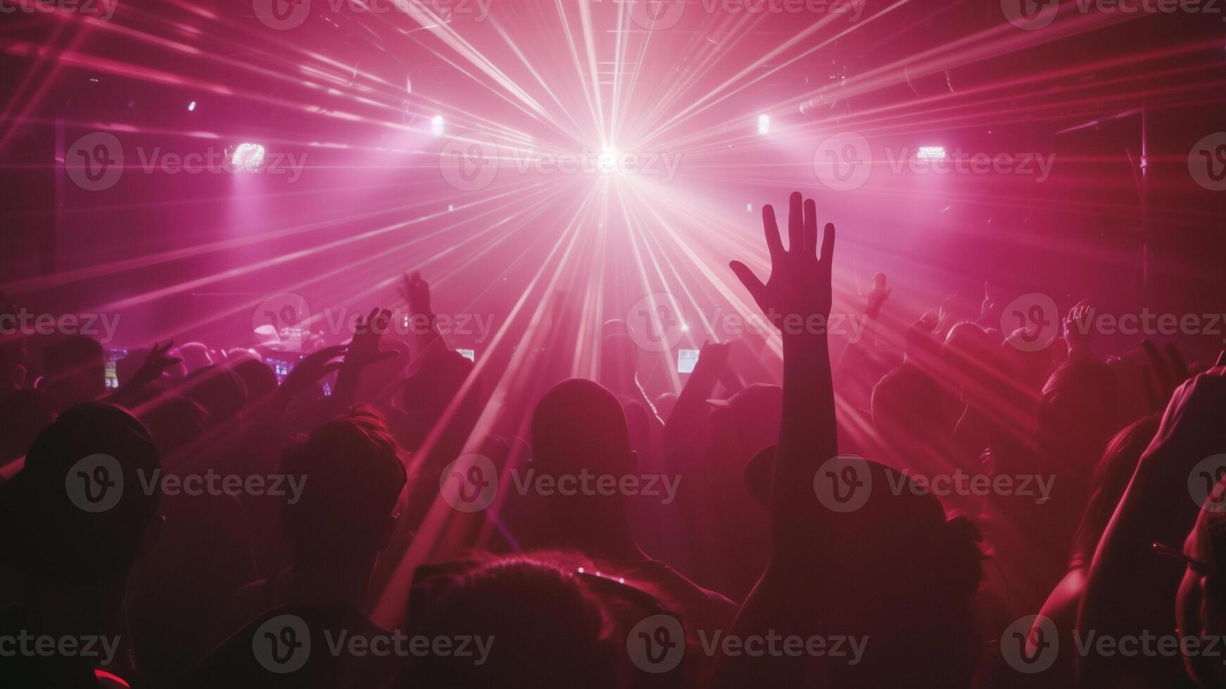 Crowd of people are at concert, with person in front of crowd holding their hand up. Atmosphere is energetic and lively, with everyone enjoying music and performance. photo