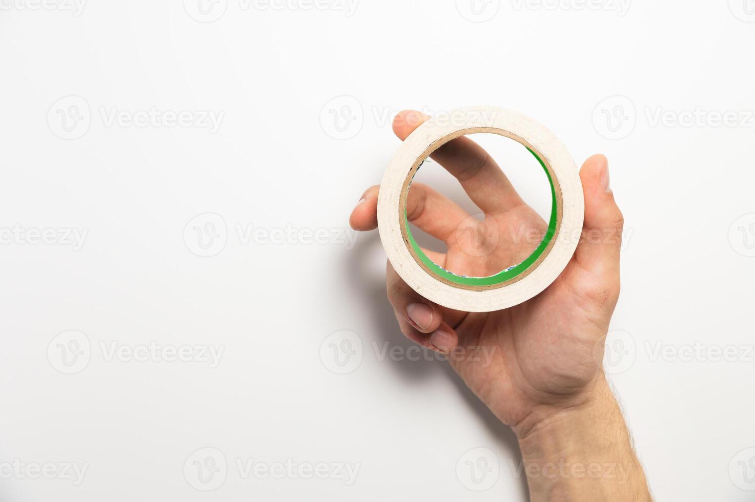 Hand holding adhesive tape on a white background. Molar tape in a man's hand, product demonstration photo