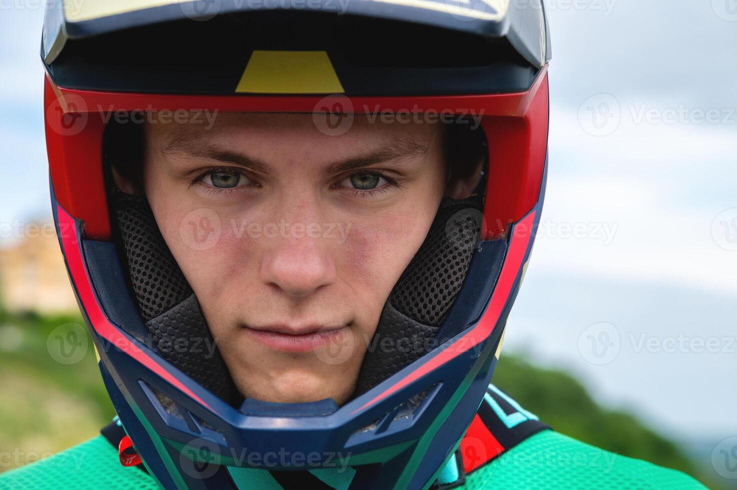 Close-up portrait of a confident handsome young athlete wearing a stylish helmet looking at the camera with eyes full of determination photo