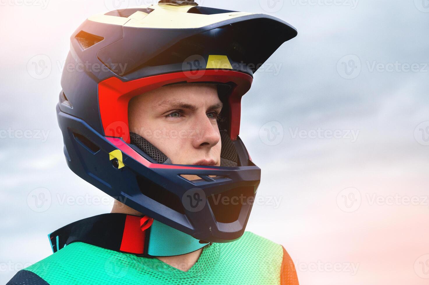 Close-up portrait of a confident handsome young athlete wearing a stylish helmet looking at the camera with eyes full of determination photo