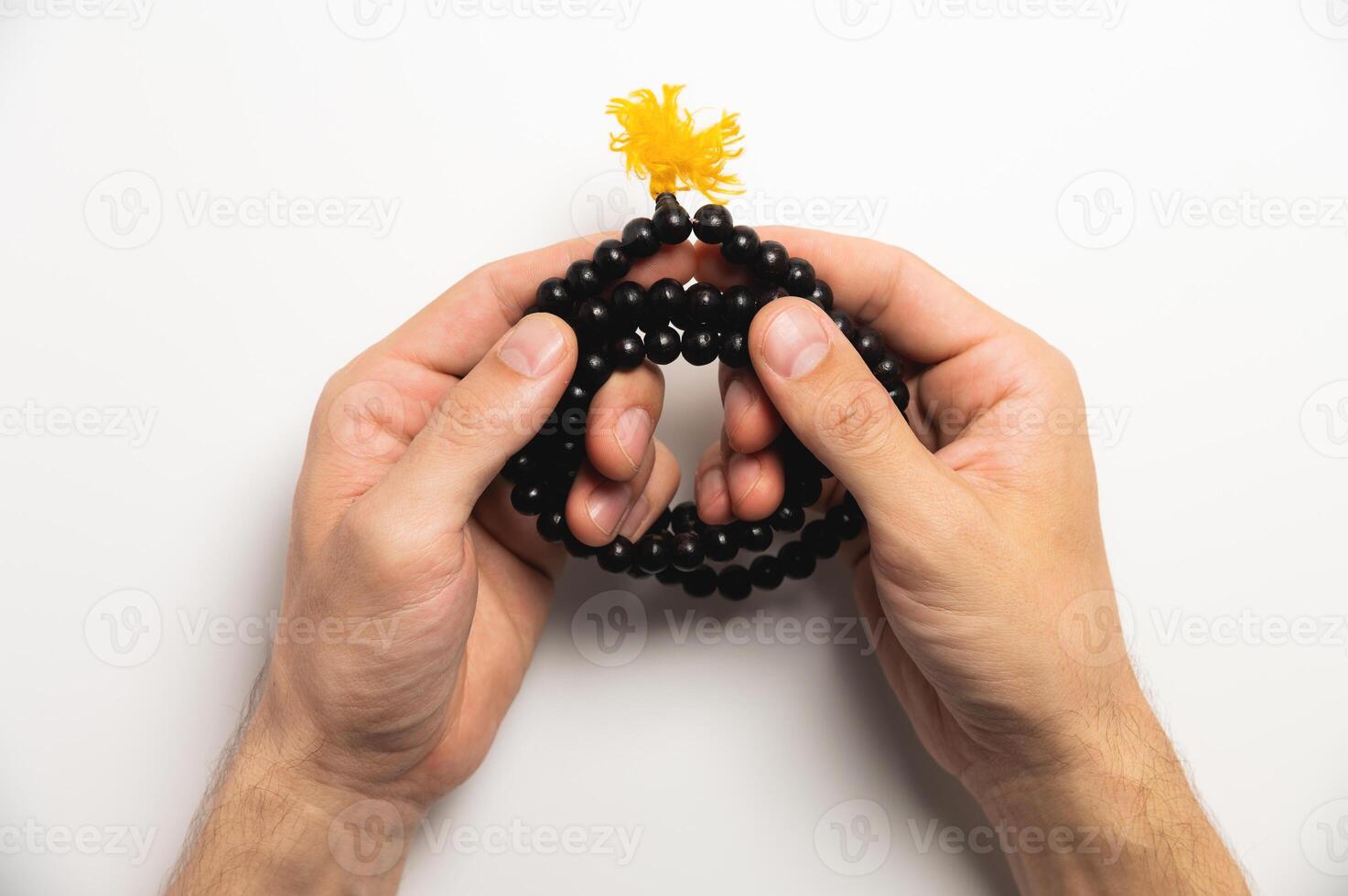 Selective focus, man's hands holding wooden rosary beads on white background photo