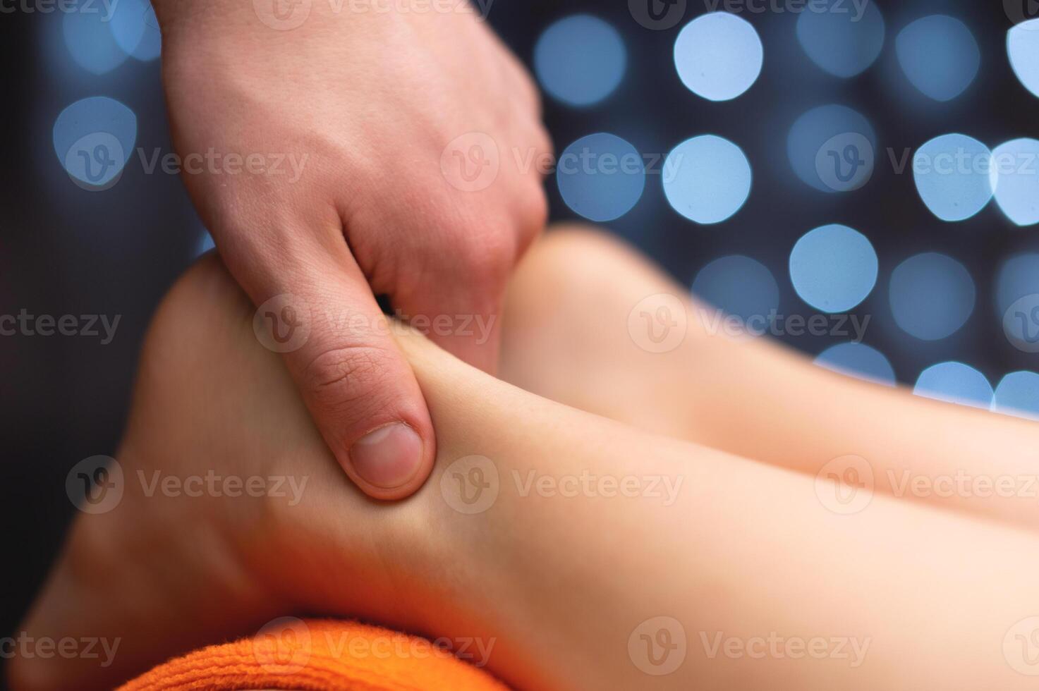 Close-up of male hands giving massage to female legs, spa salon photo