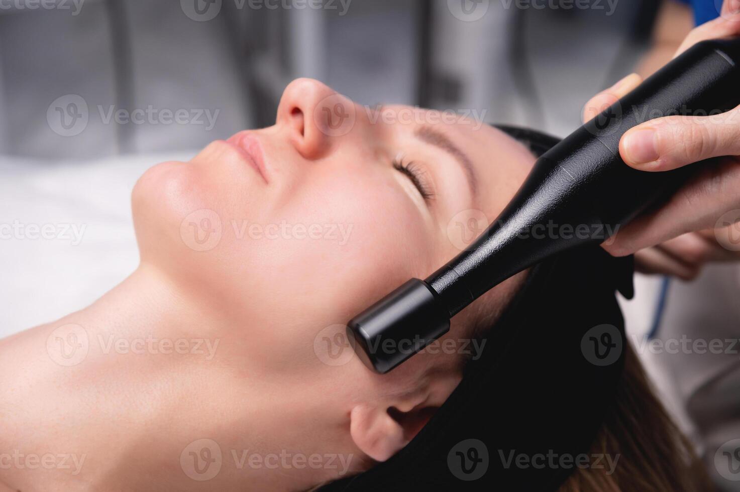 Hardware facelift procedure. Hardware cosmetology. A beautiful woman having a lymphatic drainage procedure done in a cosmetologist's office. photo
