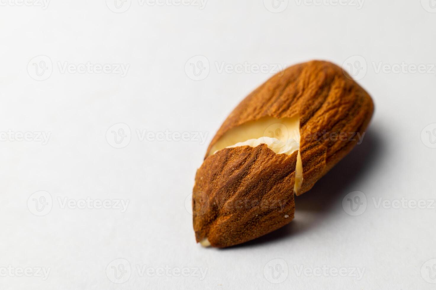 Close-up of one cracked almond seed on a white background photo