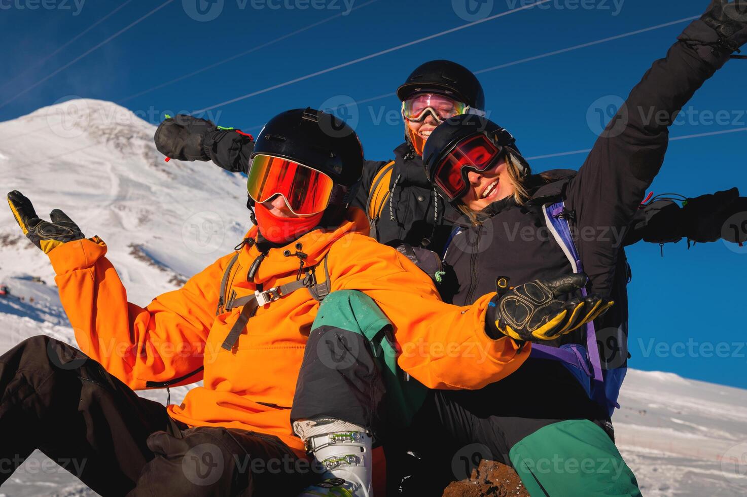 Group of young people enjoy their vacation in the mountains in winter. Hipsters in ski clothes happy while skiing and snowboarding photo