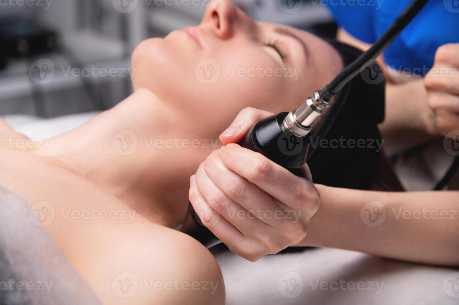 Hardware facelift procedure. Hardware cosmetology. A beautiful woman having a lymphatic drainage procedure done in a cosmetologist's office. photo
