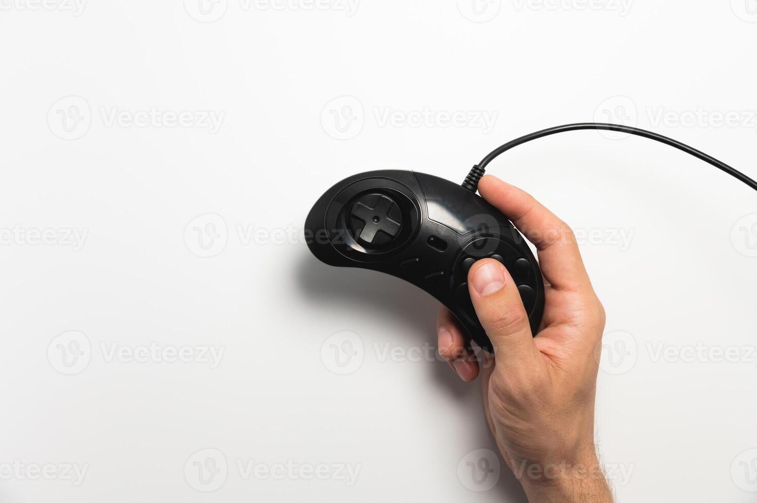 Black retro joystick on a white background in a man's hand. View from above photo