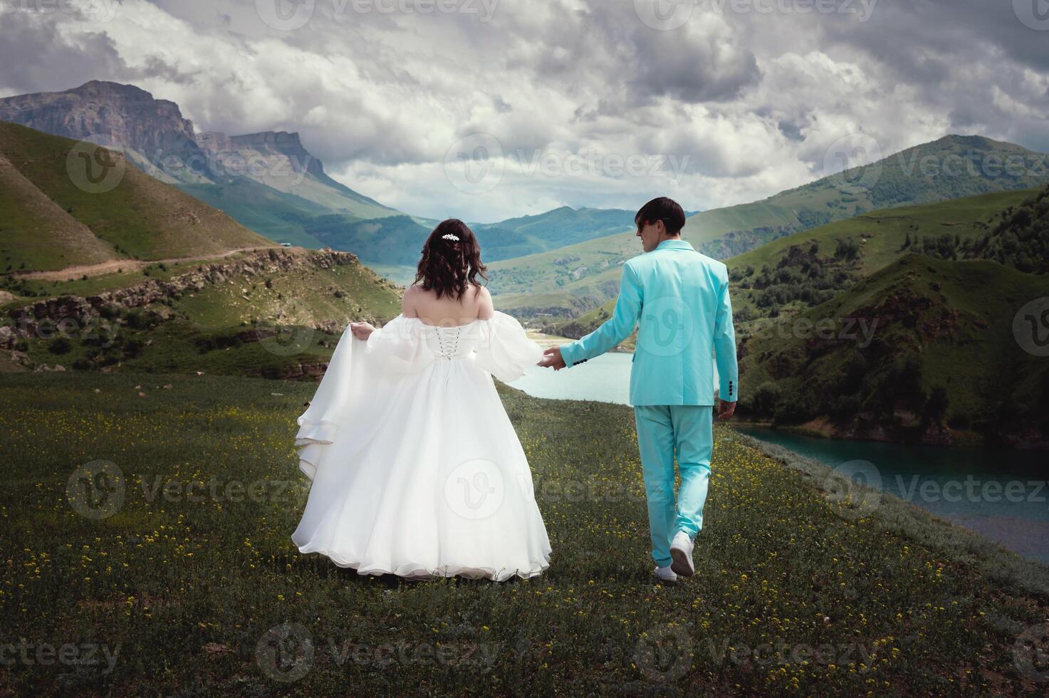 Wedding couple walking against the backdrop of beautiful scenery. Mountains covered with clouds photo