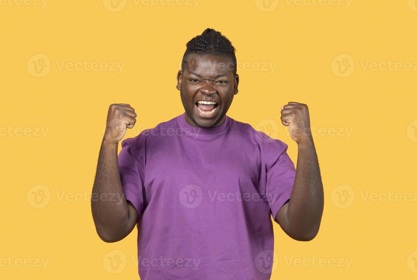 Yes, I Did It. Emotional Black Man Shaking Fists Celebrating Big Luck And Success, Looking At Camera Posing In Studio Over Yellow Background Wall. Joy Emotion, Victory Celebration Concept photo