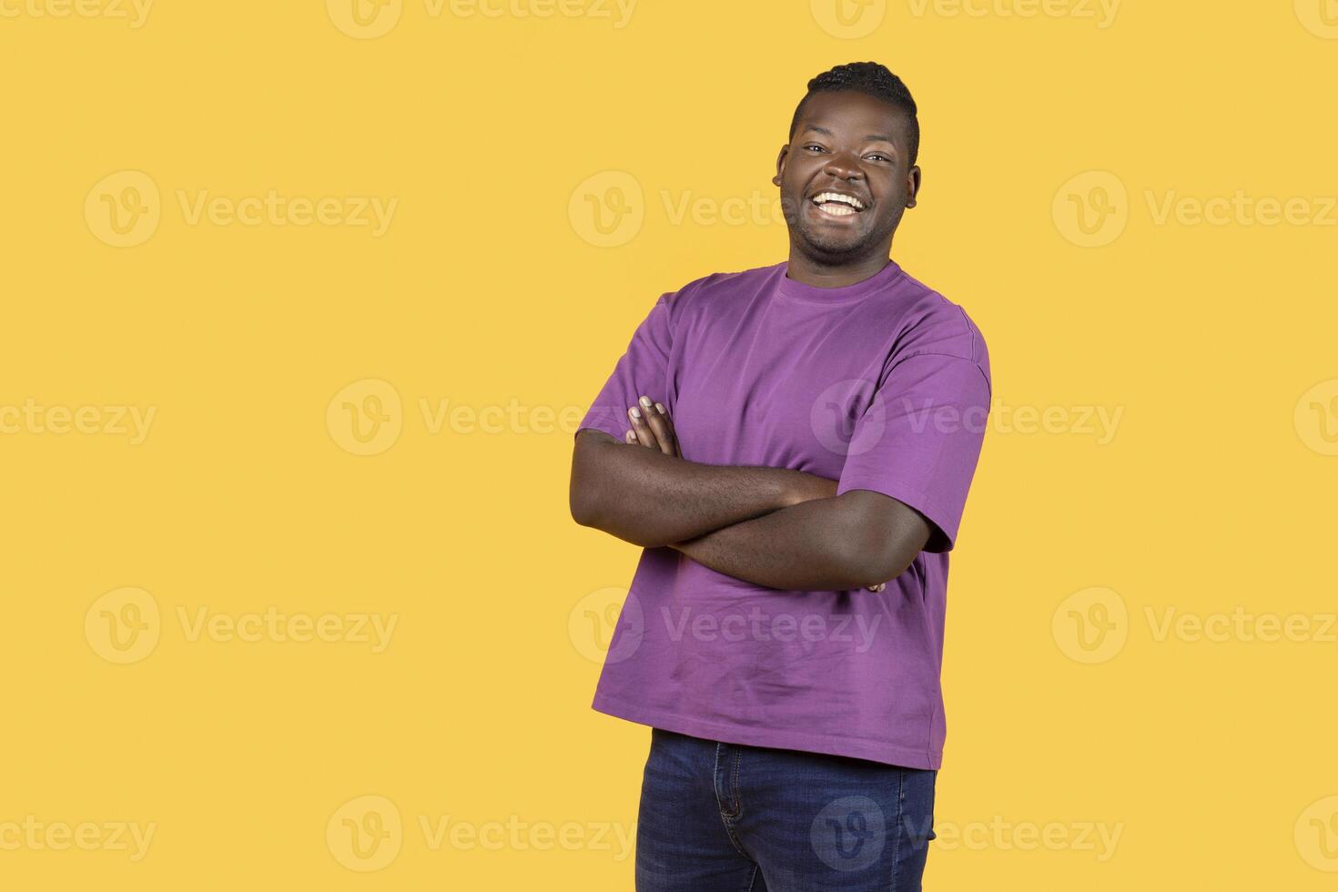 Cheerful African American Guy Posing Crossing Hands Laughing And Expressing Positive Emotions, Standing With Confidence Over Yellow Background. Studio Shot Of Happy Self Confident Black Man photo