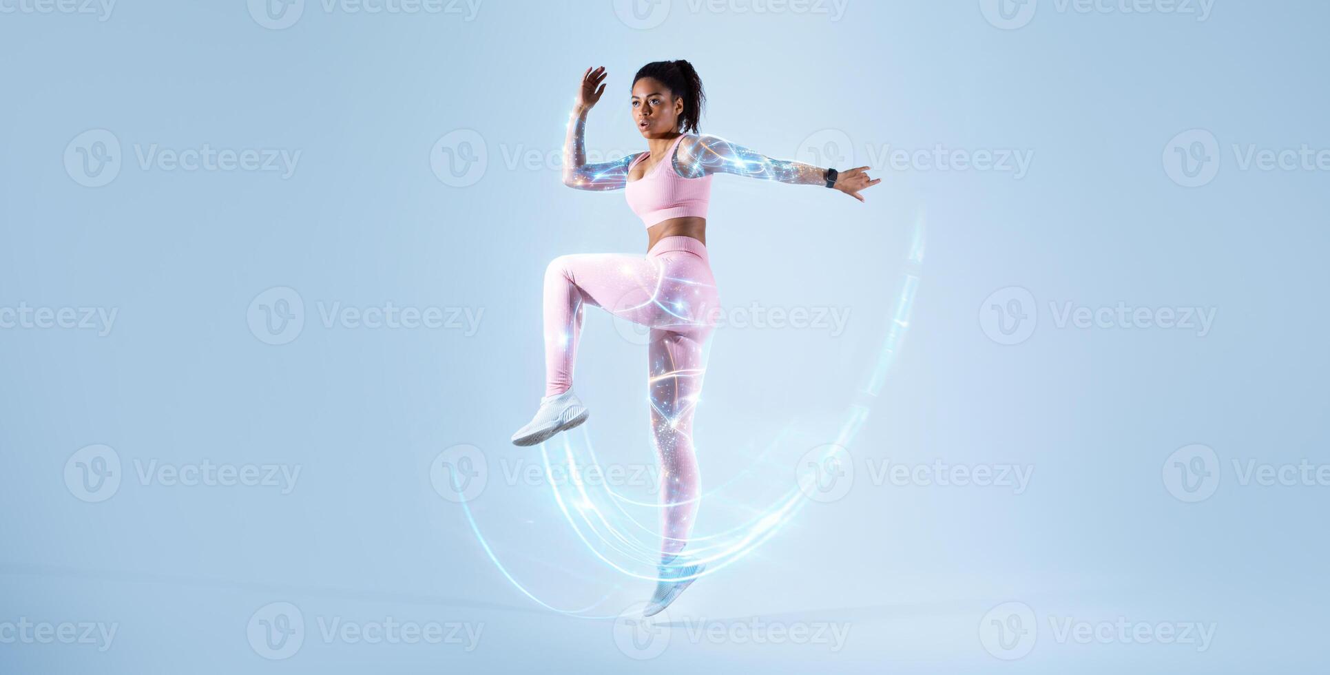 Young black woman in sportswear jogging and jumping looking at empty space, sprinting on blue studio background, full body length, banner, mockup, double exposure. Digital sport, health technologies photo