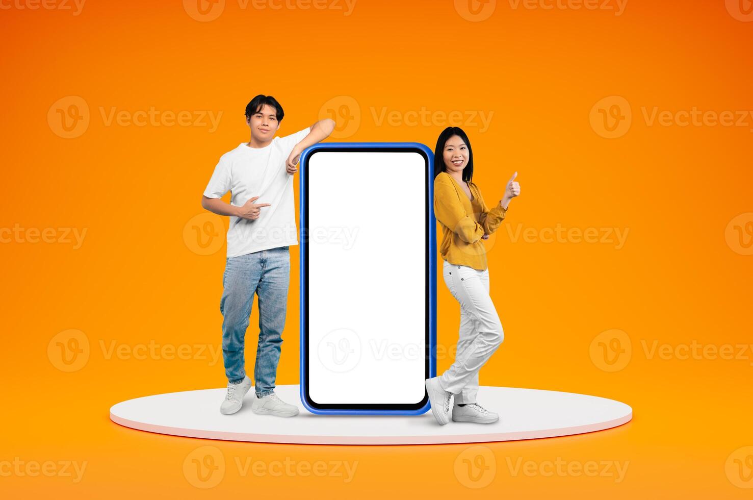 Cheerful chinese millennials casual man and woman posing on platform by big phone with white empty screen, showing thumb up, isolated on orange background, blank space. Great online offer photo