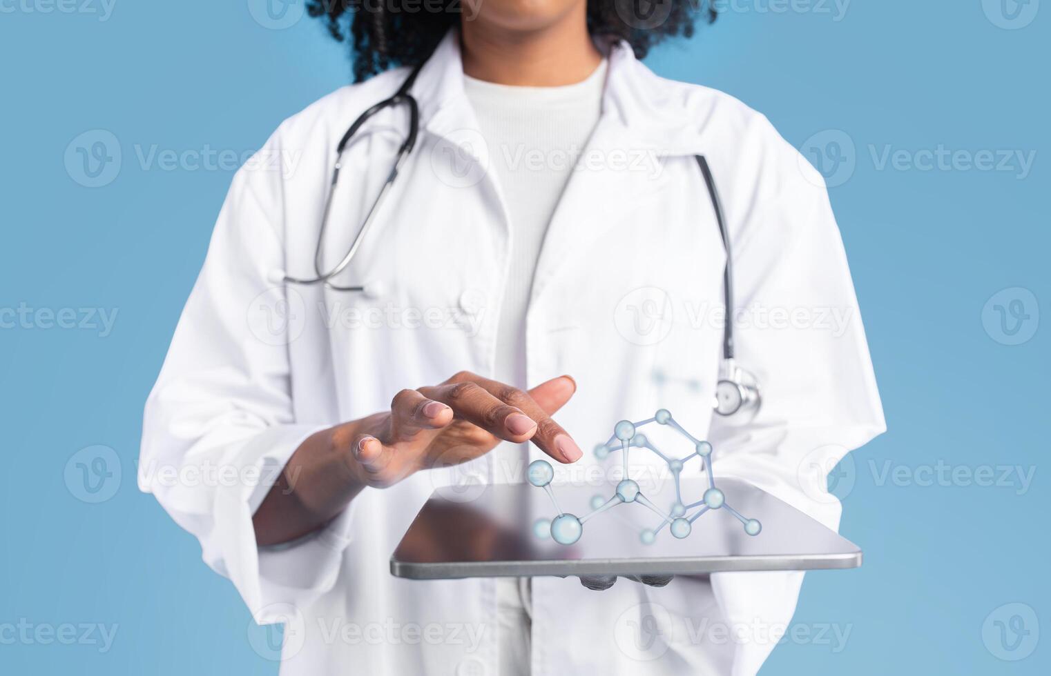 Young black woman doctor therapist in white coat uses tablet with blank screen and molecules, isolated on blue studio background, collage. App for medical, health care, science website photo