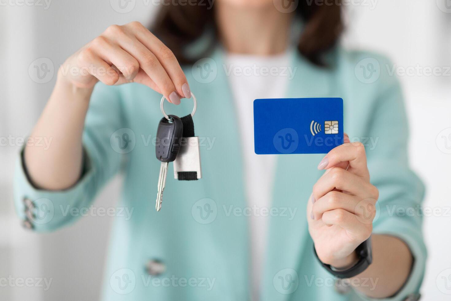 Young european lady manager in suit shows keys and credit card in office, close up, cropped. Businesswoman and business, purchase new auto, loan, money for dream, credit in bank photo
