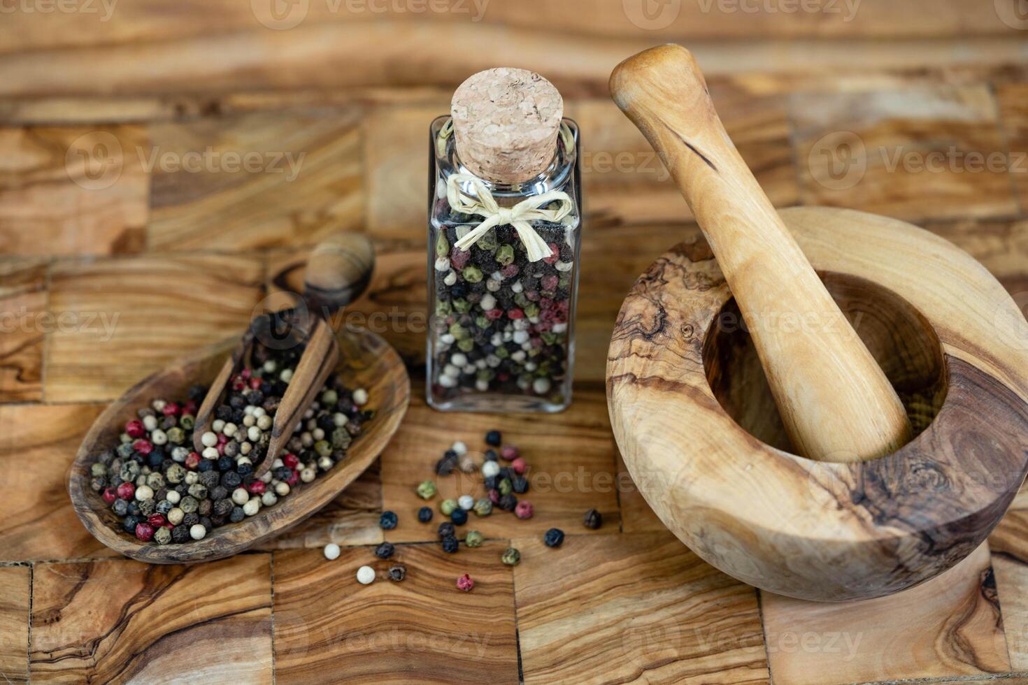 a stack of peppercorns on olive wood photo