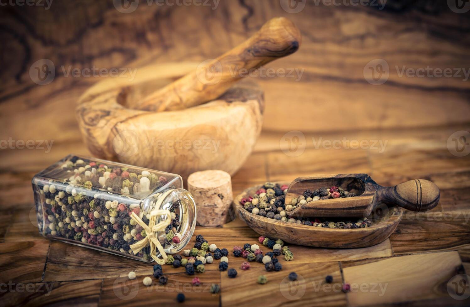 a stack of peppercorns on olive wood photo