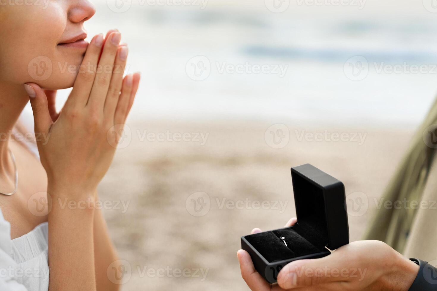 Engagement. Man asking his girlfriend the marriage question, proposing marry him on the beach, closeup, cropped. Love, relationship concept photo