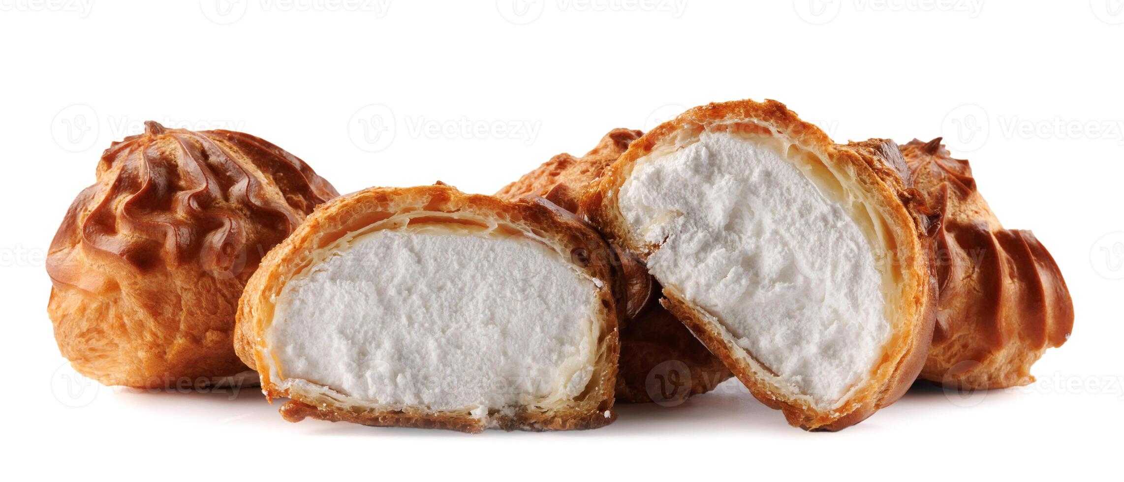 Cut in half and whole porophytroles with white cream isolated on a white background. Eclair with cream. photo