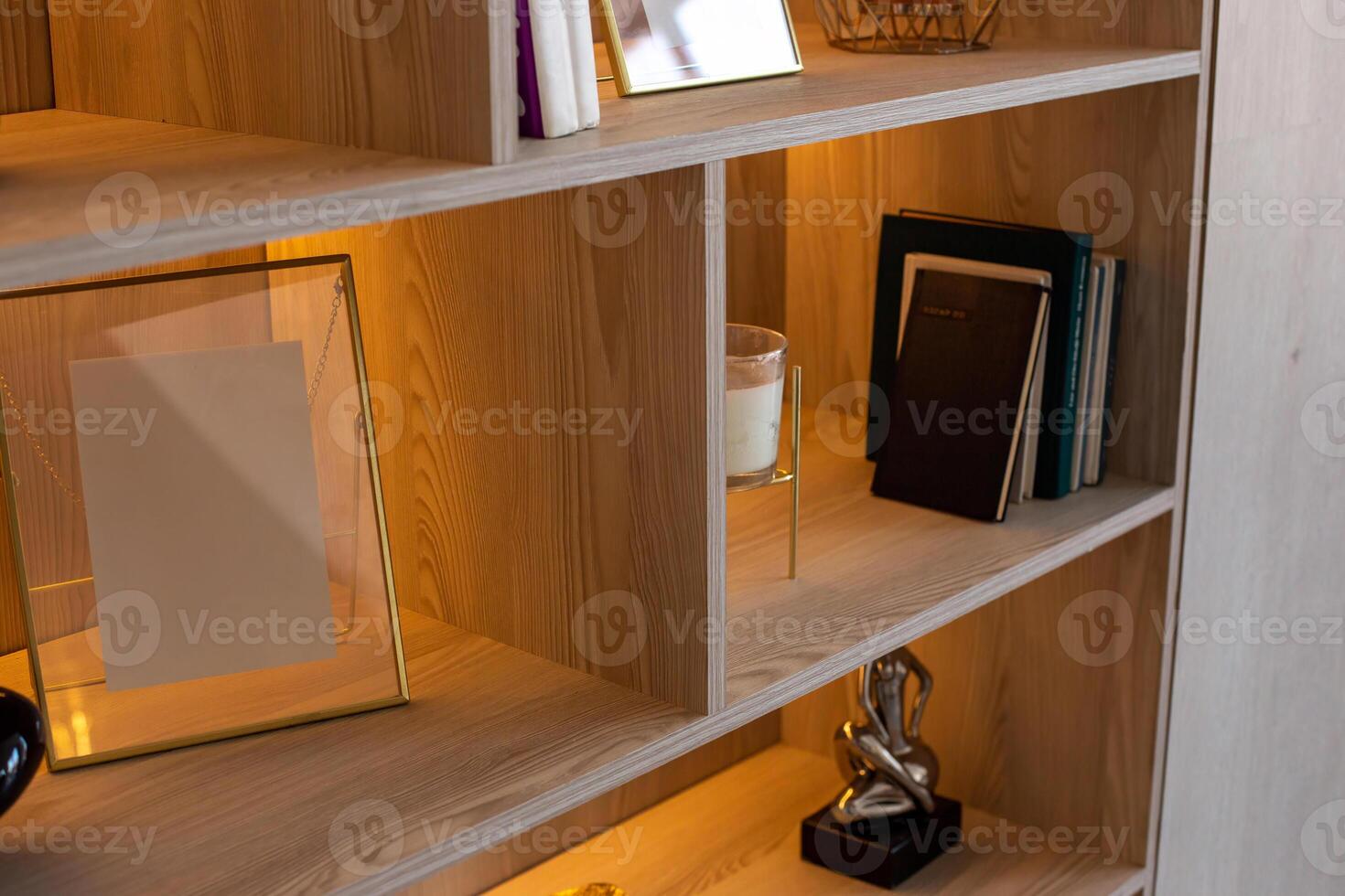 A shelving with figurines, frames, books with warm lighting photo