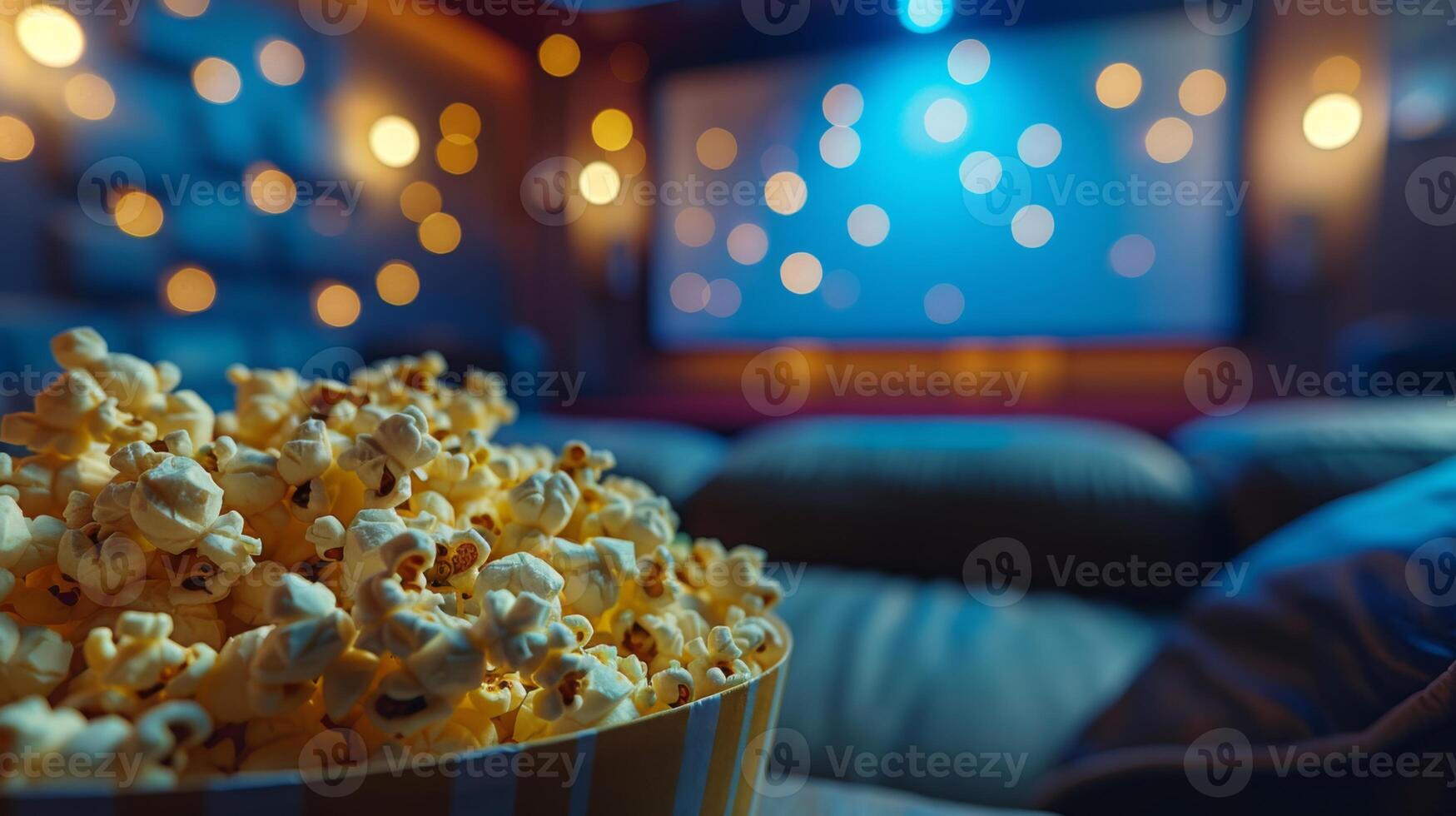A bowl of freshly popped popcorn sits on a table in a cozy home theater setup, with a screen and ambient lighting in the background. photo
