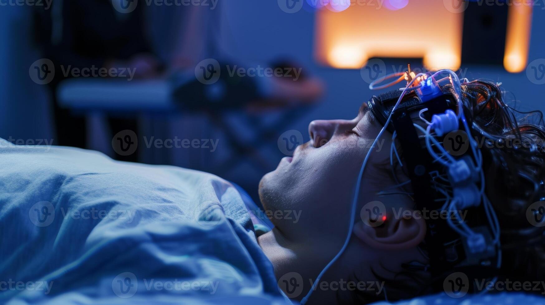 An EEG headset being worn by a participant in a sleep study with researchers monitoring brain activity in the background photo
