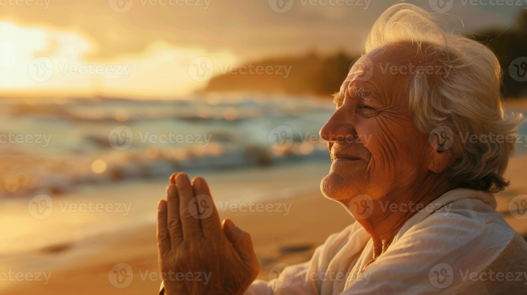 An elderly person smiling while practicing meditation at a peaceful beach photo