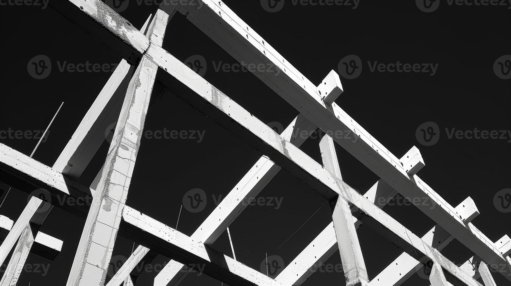 The beams of the unfinished structure are outlined in white against the black sky creating a striking contrast photo