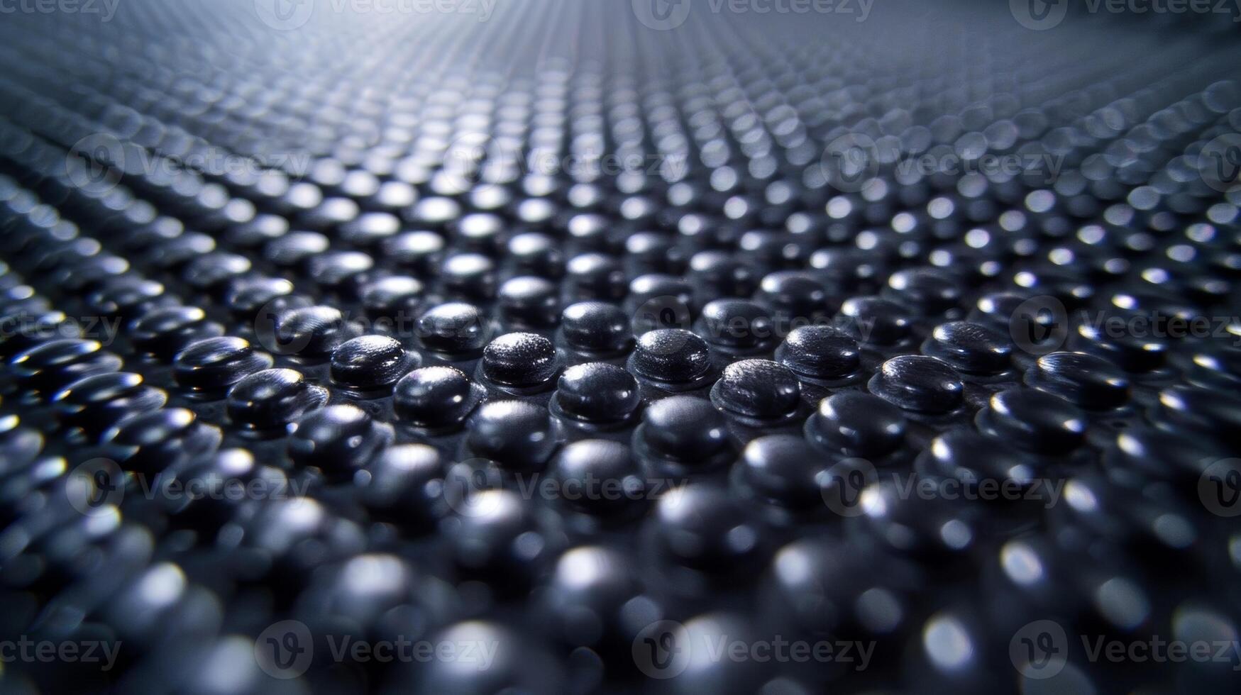 A closeup view of a conveyor belt comprised of small tightly spaced bumps that resemble a field of goosebumps on the rubber surface photo
