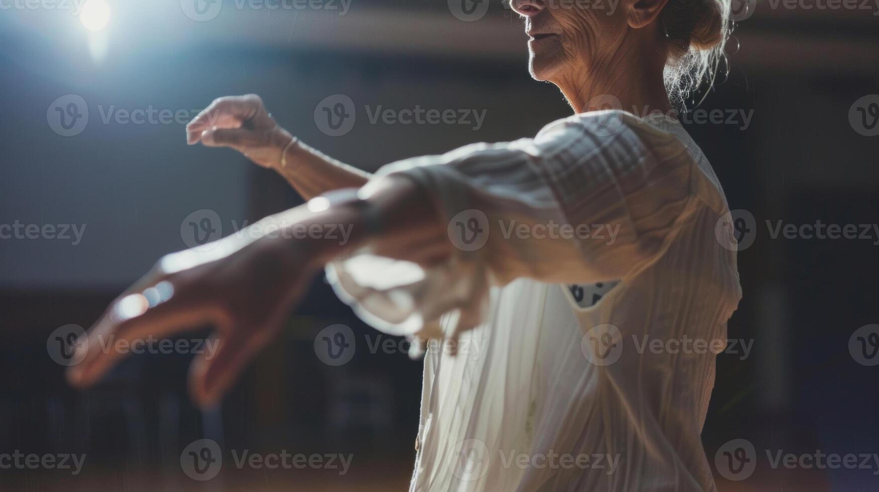 A woman in her 60s does a solo performance spinning and gracefully moving across the dance floor with ease photo
