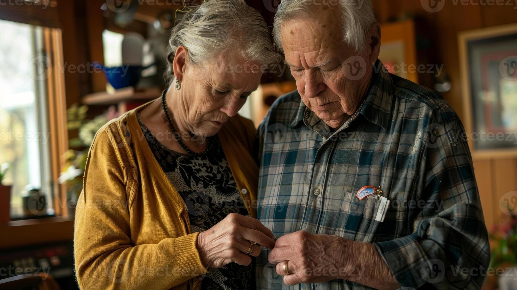 A man helping his wife with Parkinsons disease button her shirt as her hands tremble and struggle to do it herself photo