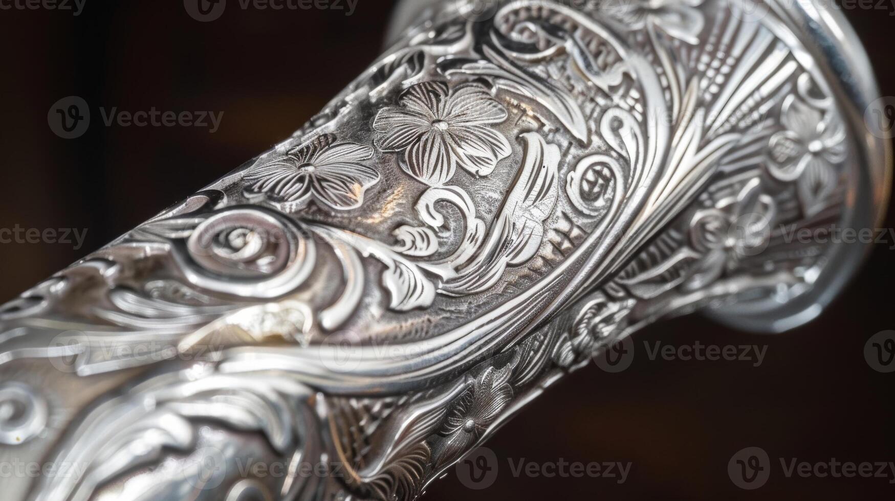 A silver walking stick with intricate floral engravings photo