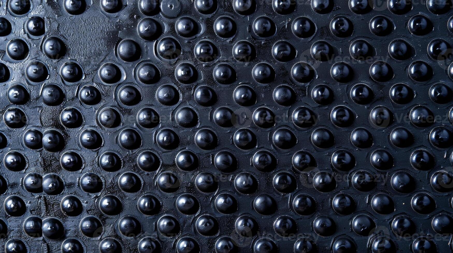A top view of an industrial rubber mat exposing its bumpy surface with small raised dots perfect for providing grip and traction in a high traffic area photo