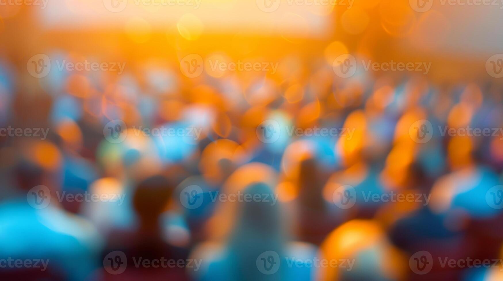 Fuzzy figures and a blurred backdrop at a packed public lecture photo