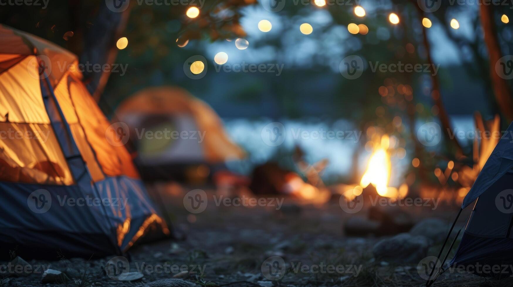 Blurred outlines of tents and a distant campfire adding to the serene atmosphere of a campsite photo