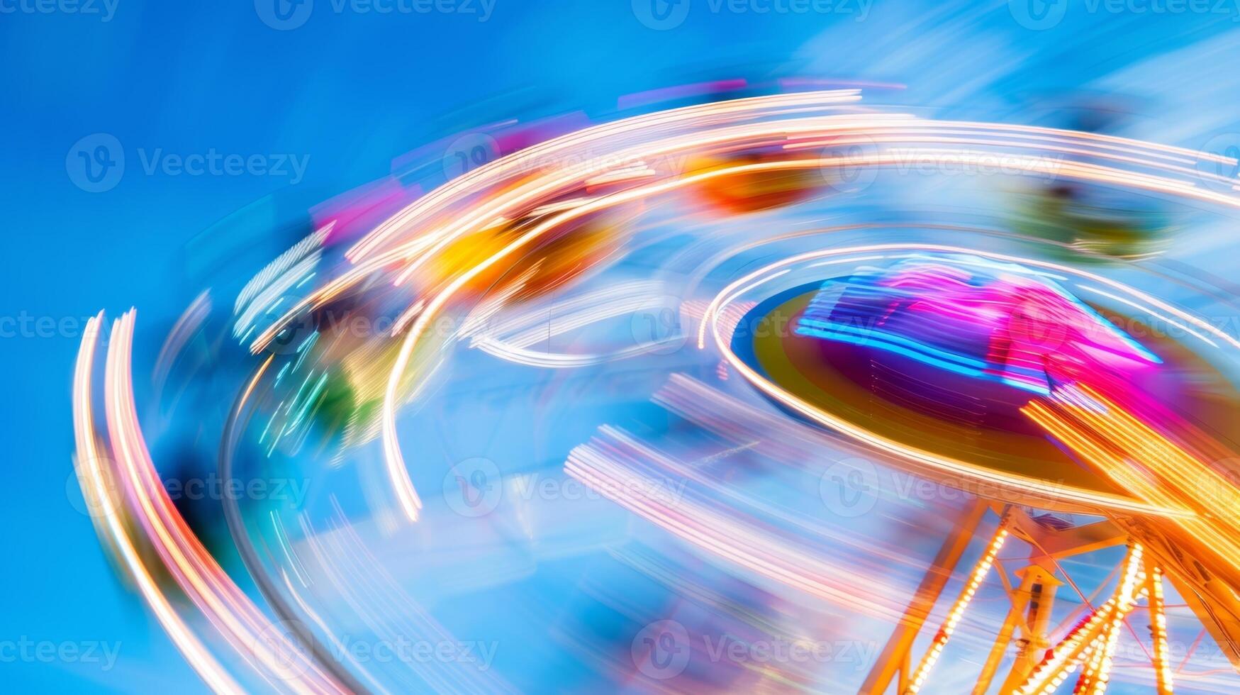 A blur of bright spinning Ferris wheel carts against a blue sky photo