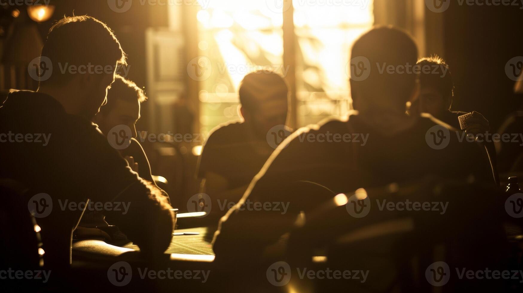 Softly defocused silhouettes of players gathered around a blackjack table their faces revealing a mixture of tension and excitement as they hope to beat the odds and win big creating photo