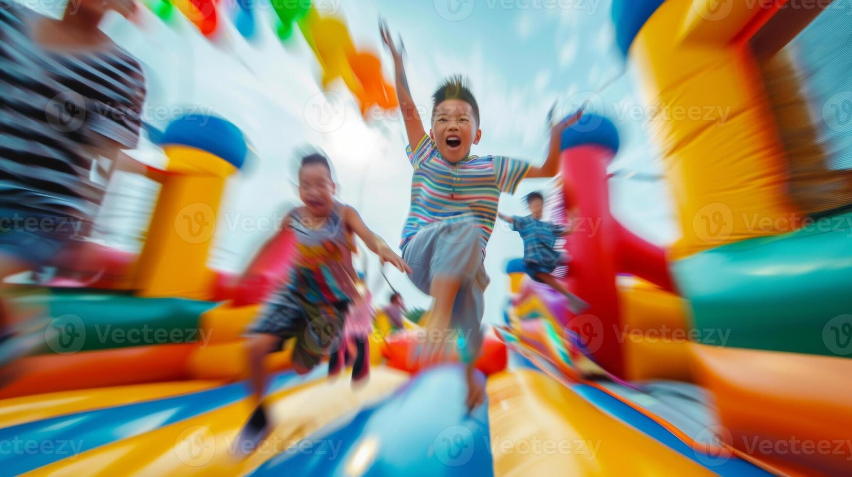 A blurred background of multicolor bounce houses and bouncy castles adding to the energetic chaos and excitement of a group of children jumping for joy. photo