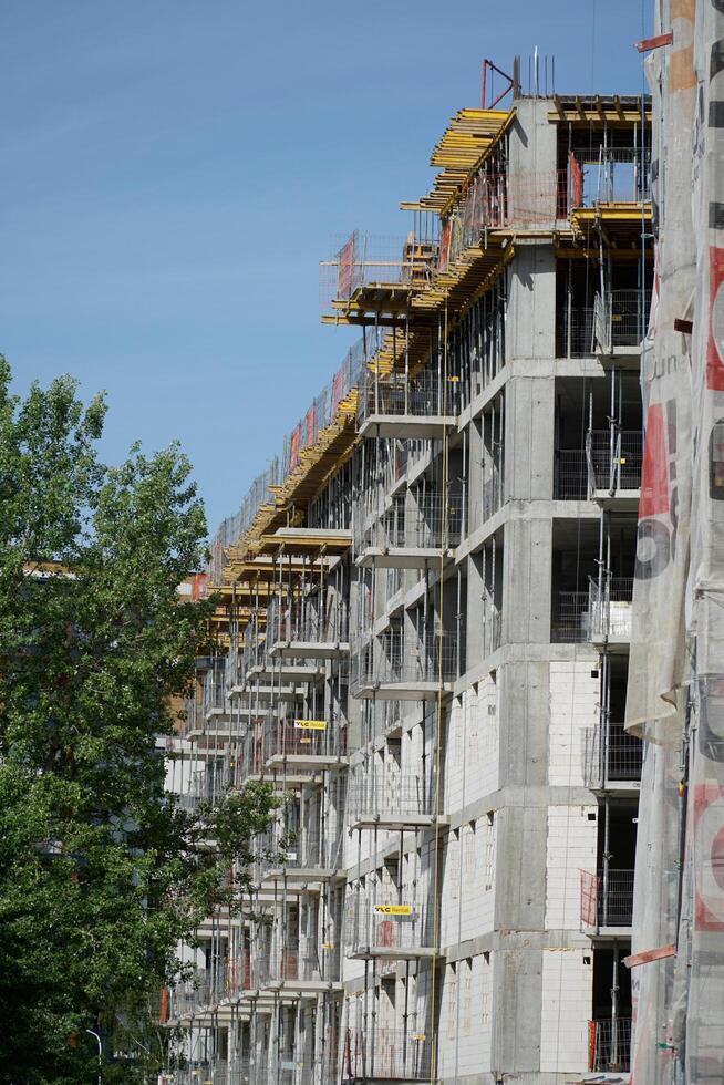 Warsaw, Poland, May 3rd 2024 - Building under construction with scaffolding and tree photo