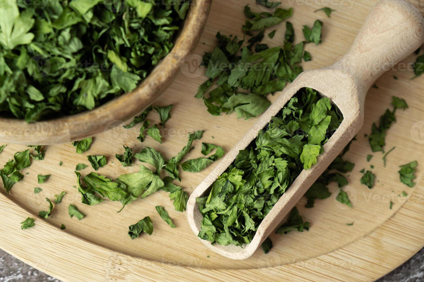 Dry parsley spice with wooden spoon in wooden bowl. Homegrown herbs and spices for cooking. Fresh dried aromatic natural food ingredients. Copy space photo