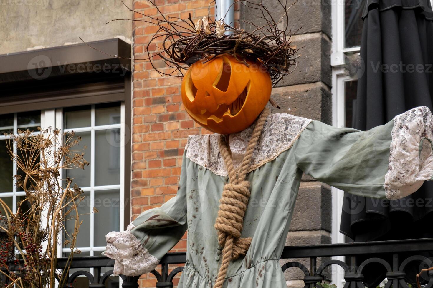 Fall mystery scarecrow in autumn outside. Thanksgiving or Halloween holiday decoration. House entrance in festive seasonal decor. Atmosphere aesthetic photo