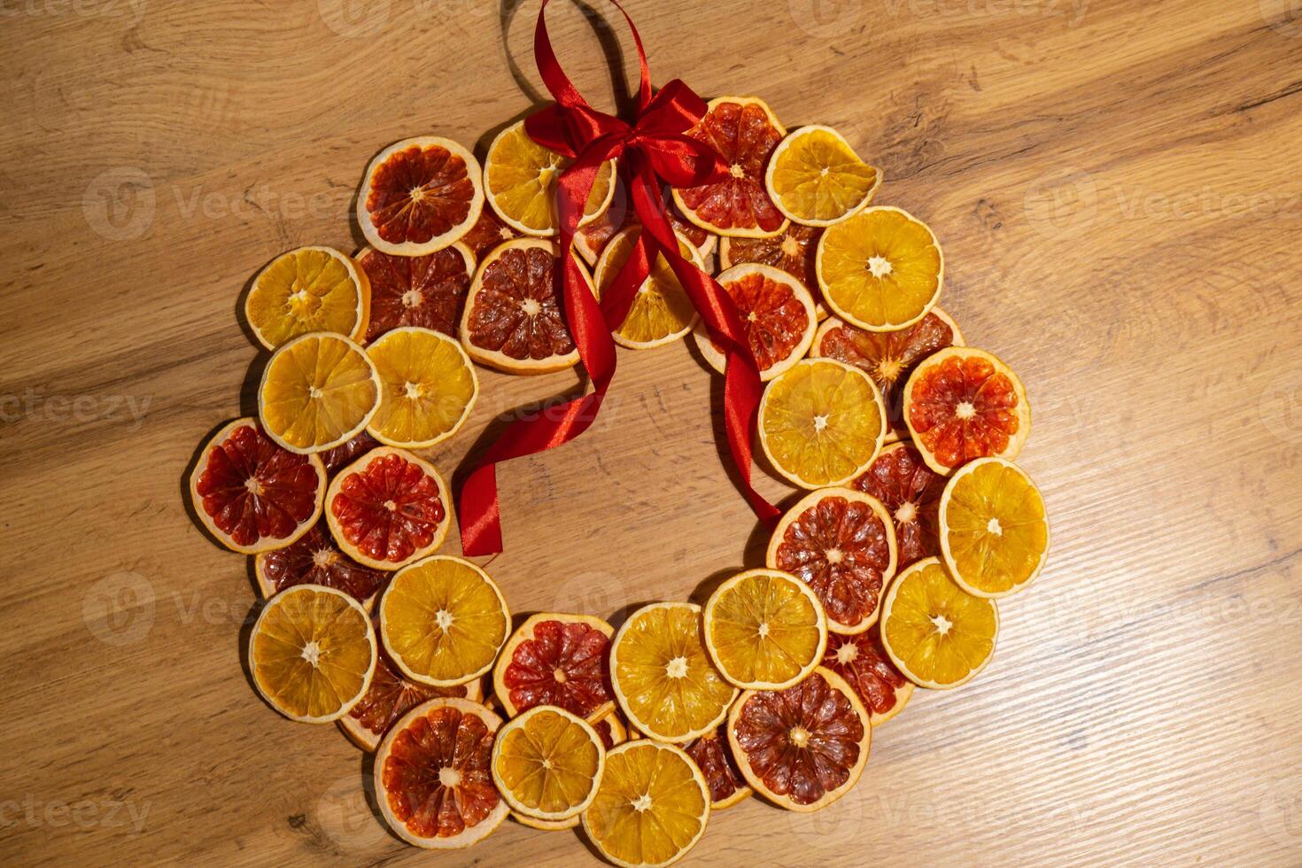 Step 4 Step by step instruction of making handmade Christmas wreath made of dry fruits oranges and grapefruits. Female hands creating craft homemade decor. New year celebration. Winter holidays photo