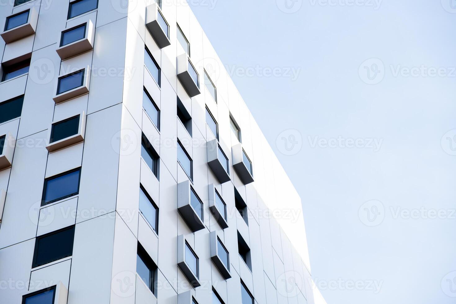 Modern white building with square windows. Multistory apartment building. Minimalistic Stylish living block of flats. Facades of modern office building. Exterior texture pattern. Visual art. Conceptual photo
