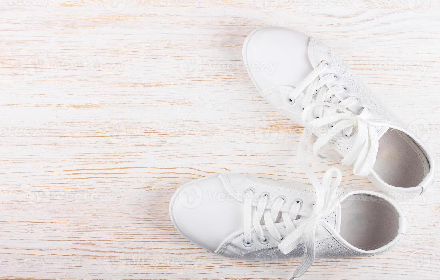 White sneakers on white wooden background. copy space. photo