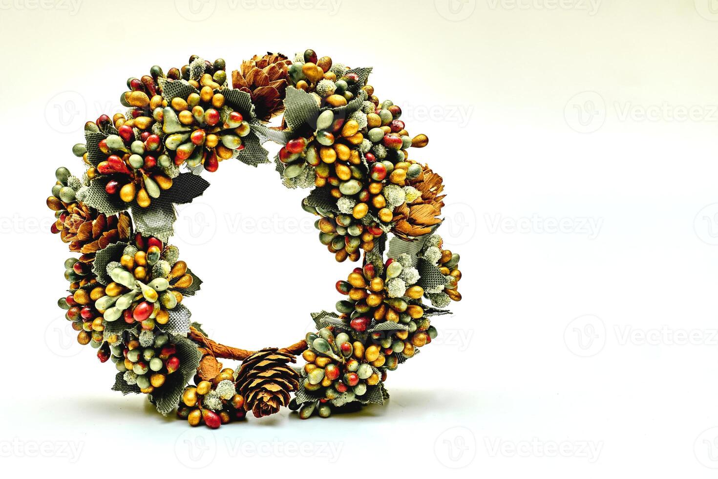 Artificial green brown wreath with leaves cones berries isolated on white photo