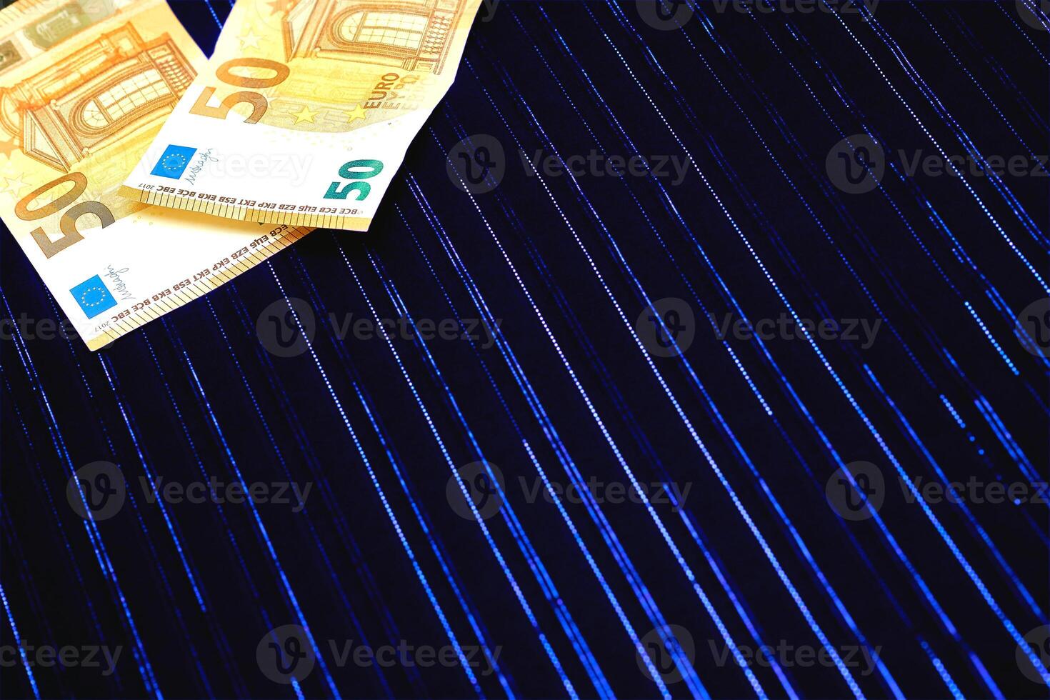 Money. Two 50 euro banknotes on dark blue fabric with lurex photo