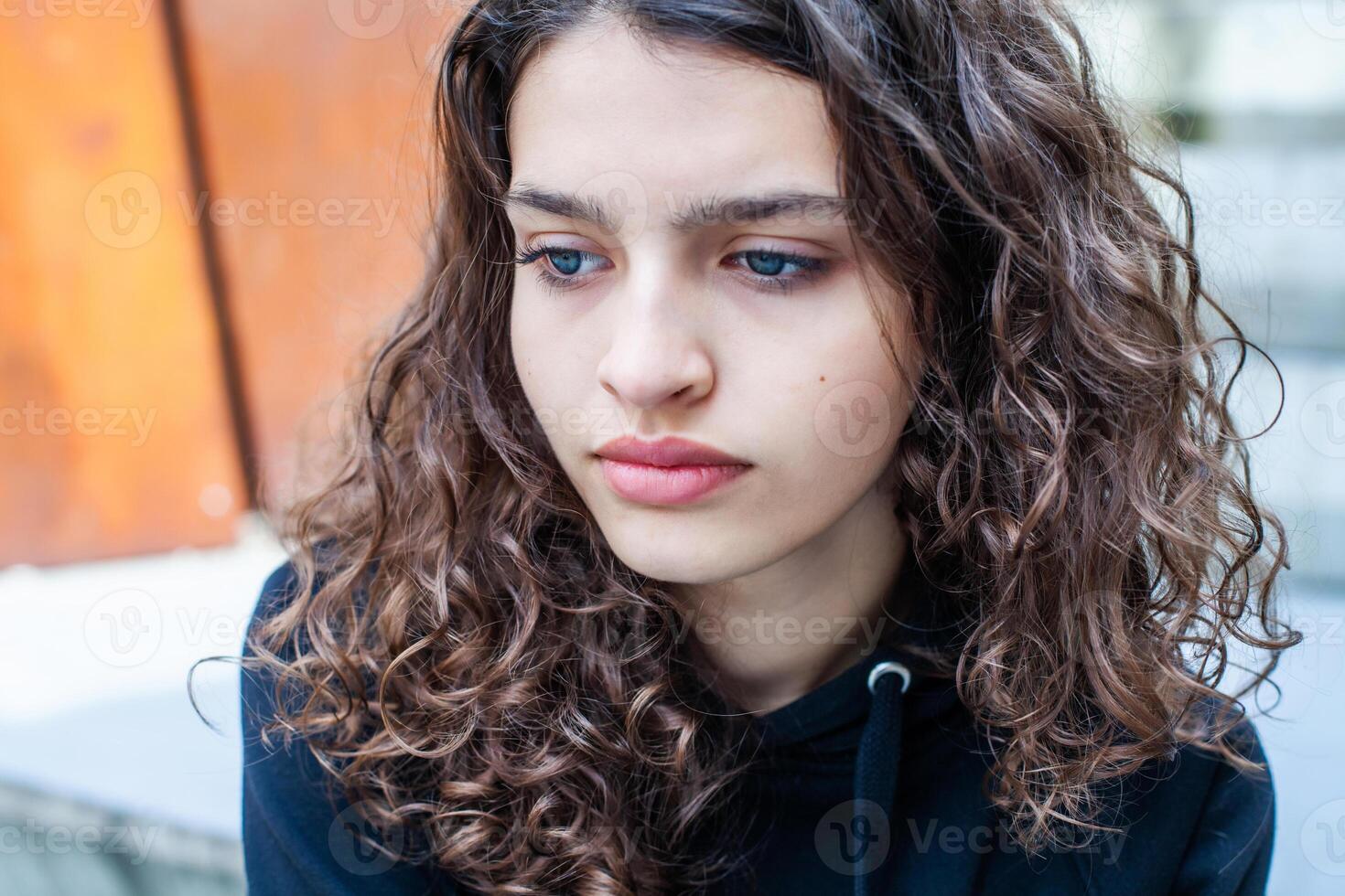 White teenager with curly hair and the most beautiful natural lips. Young girl face. photo