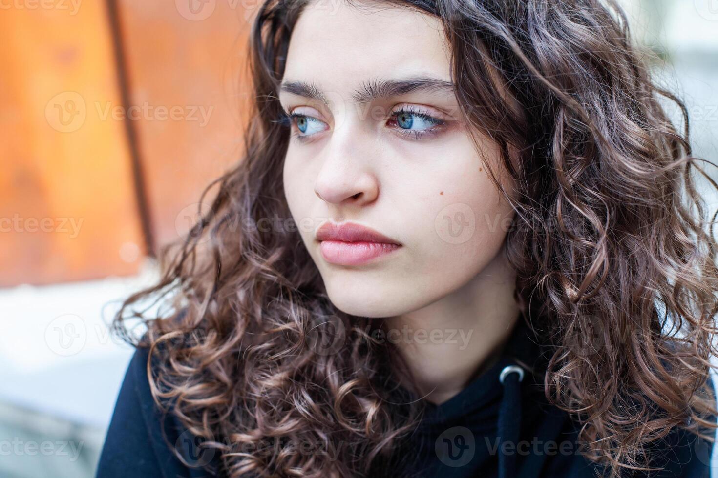 White teenager with curly hair and the most beautiful natural lips. Young girl face. photo