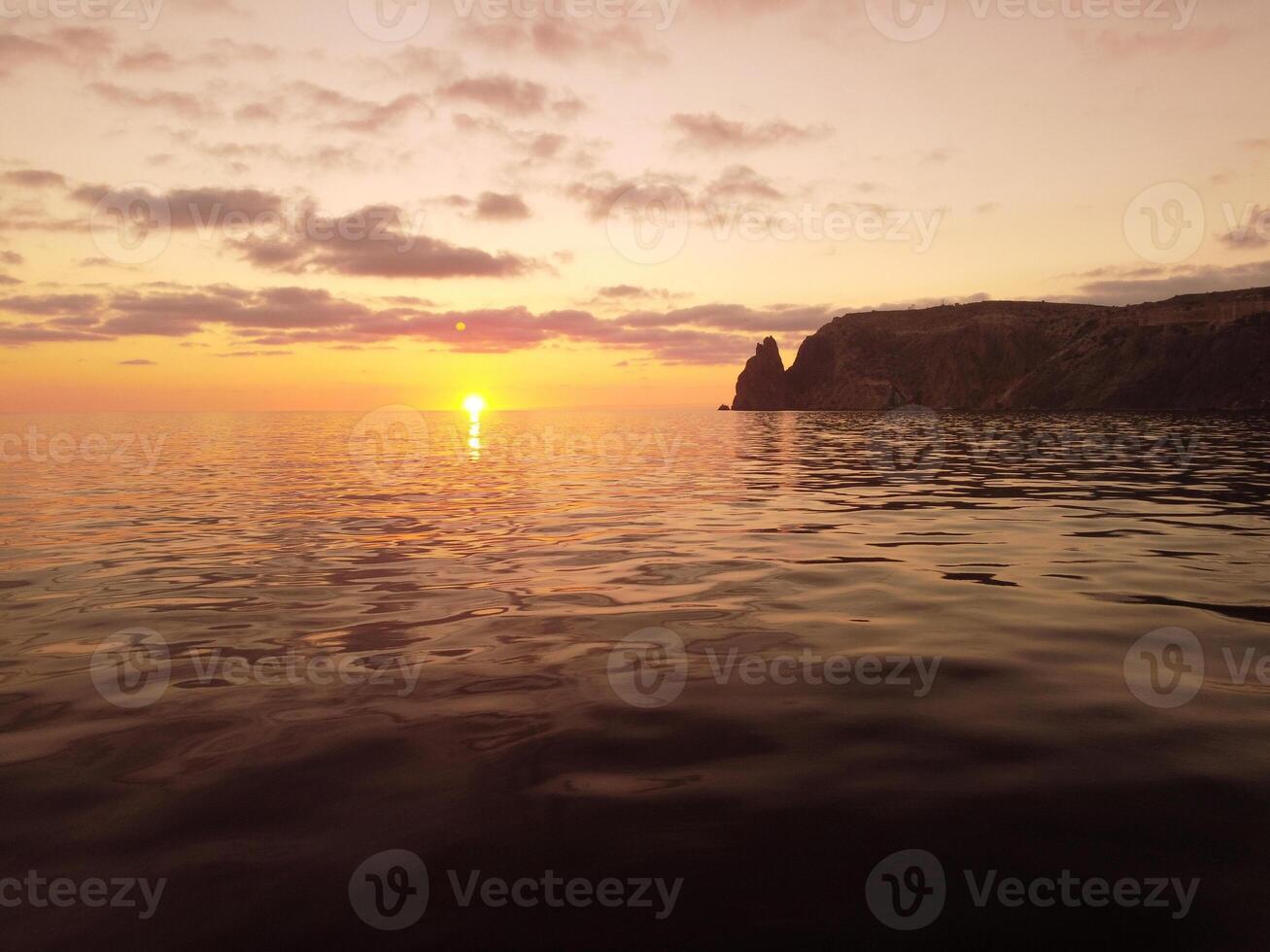 Aerial view on sunset over calm sea and volcanic rocky shores. Small waves on water surface in motion blur. Nature summer ocean sea beach background. Nobody. Holiday, vacation and travel concept photo