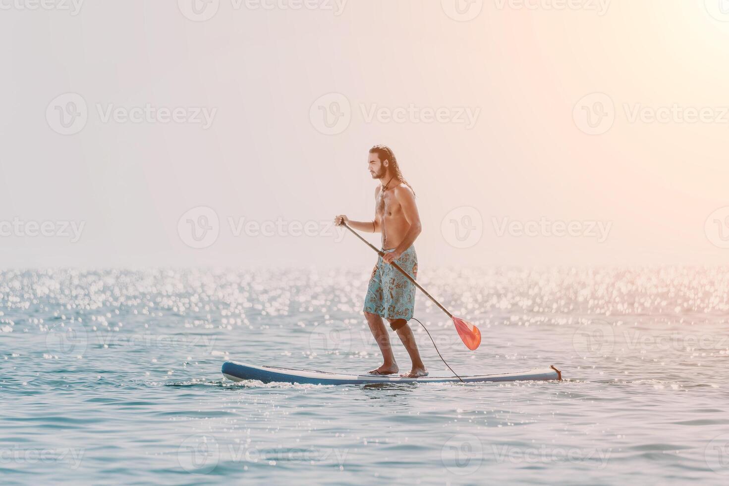 Man Sup Sea. Strong athletic man learns to paddle sup standing on board in open sea ocean on sunny day. Summer holiday vacation and travel concept. Aerial view. Slow motion photo